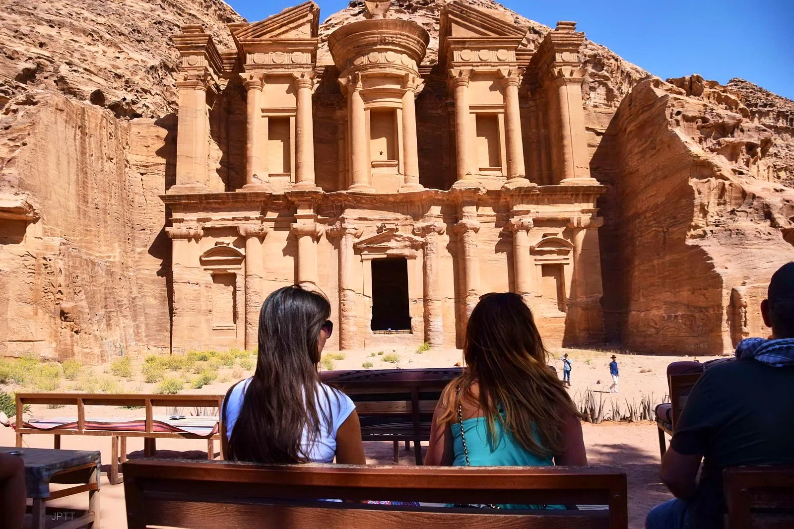 Travellers sitting at the viewpoint café facing the Monastery at Petra